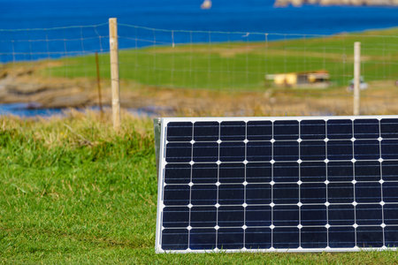 Single solar photovoltaic panels, charging batteries outdoors against sea landscape. Camping trip....