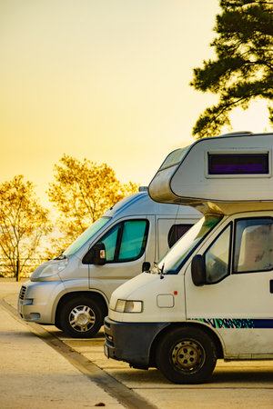 Camper cars recreational vehicle parking on roadside. Holidays and travel in motor home.