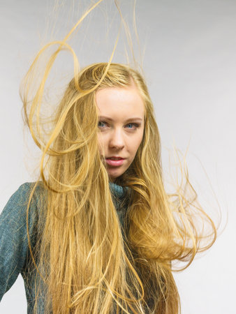 Young female with long hair flying around her face. Haircare concept.の写真素材