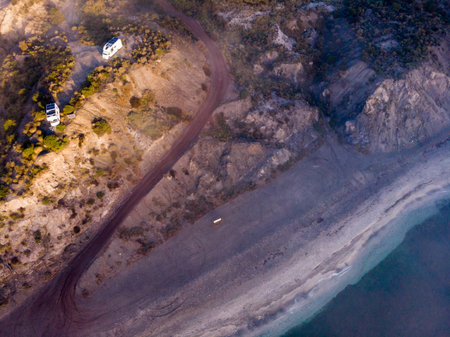 Aerial view of seaside landscape. Two camper vehicles with solar panels on roof camping on coastal cliff in Spain. Caravan vacation.の写真素材