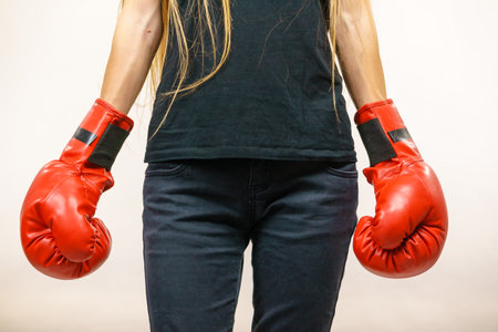 Young woman in big red boxing gloves. Female fight for equal rights for women.の写真素材