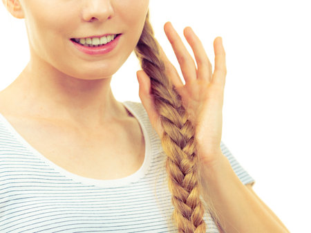 Blonde girl with long braid hair. Haircare, hairstyling, feminine style.の写真素材