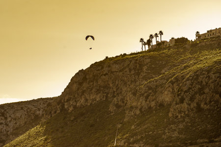 Paragliding. Extreme sports. Paraglider silhouette flying in the sky.の写真素材