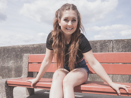 Happy joyful smiling woman spending her free time outside enjoying beautiful summertime weather.の写真素材