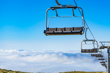 Empty chair lift in high mountain above clouds. Torre mountain peak of Serra da Estrela in Portugal.の写真素材