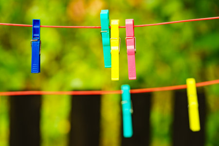 Clips for washing laundry clothes pegs on string rope outdoor. Housework concept