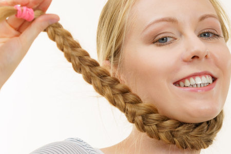 Blonde girl with long braid hair around the neck. Haircare, hairstyling.