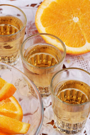 orange liqueur in small glasses with fruit nearの写真素材