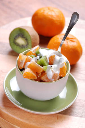 kiwi and tangerine salad in ceramic bowlの写真素材