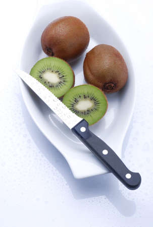 Kiwis cut with knife on white backgroundの写真素材