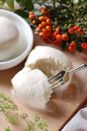 Sliced mozzarella with fork on wooden boardの写真素材