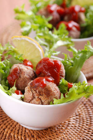 Meatballs in tomato sauce with lettuceの写真素材