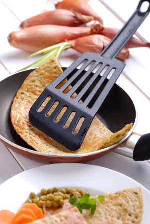 omelette with peas in the frying panの写真素材