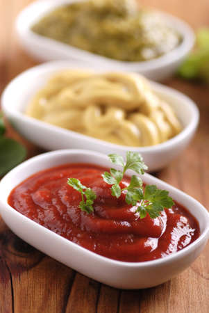 ketchup and other sauces in white bowls