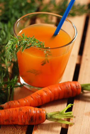 Carrot juice in the glass on white tableの写真素材