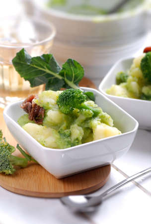 soup with potato, broccoli and anchovies in small white bowlの写真素材