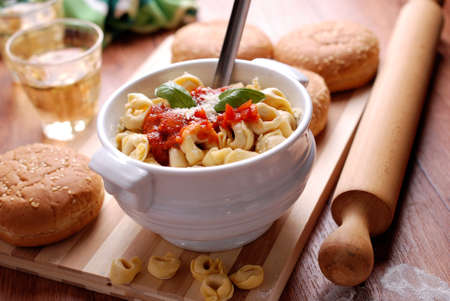 tortellini with tomato sauce and cheese in a bowlの写真素材