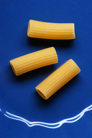 Italian raw pasta on blue dishの写真素材