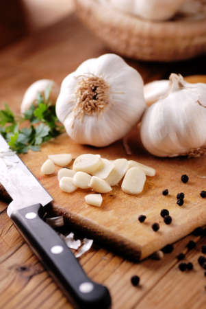 sliced garlic on wooden chopping boardの写真素材