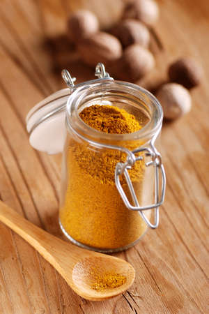 curry in the glass jar on wooden tableの写真素材