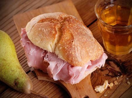 ham sandwich on wooden chopping boardの写真素材
