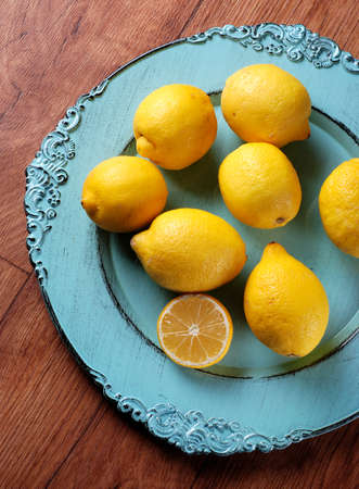 lemons on blue plate on wood tableの写真素材