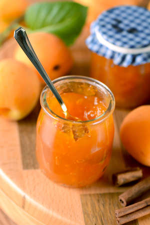 apricot jam in glass jar with fruit aroundの写真素材