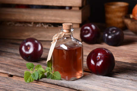 prune juice in small glass bottle with fruit aroundの写真素材