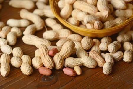 peanut seeds in the bowl on the wooden table