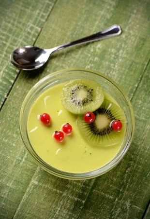 kiwi dessert decorated with red currants in glass bowlの写真素材