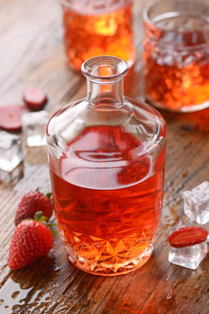 strawberry liqueur on the table with fruit aroundの写真素材