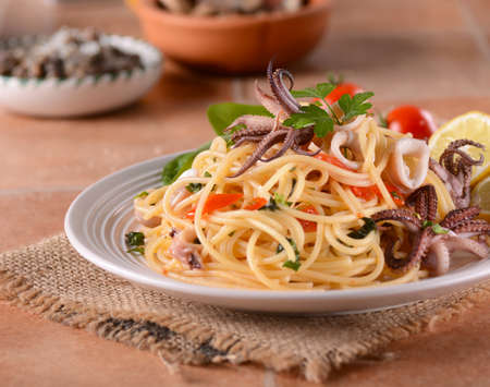 spaghetti with squid and cherry tomatoesの写真素材