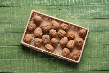 Walnuts in the basket on the green table