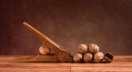 pile of organic walnuts with nutcracker on the wooden tableの写真素材