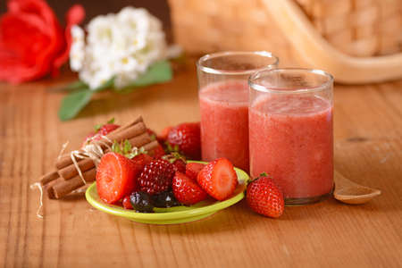 fruit smoothie with strawberries and berries with ingredients aroundの写真素材