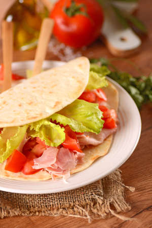 piadina with ham, tomato and vegetables - Traditional Italian recipeの写真素材
