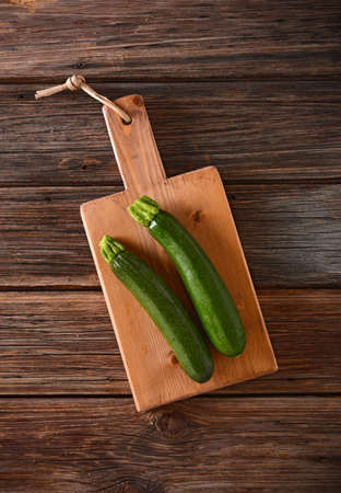 cutting board and zucchini on the wooden tableの写真素材