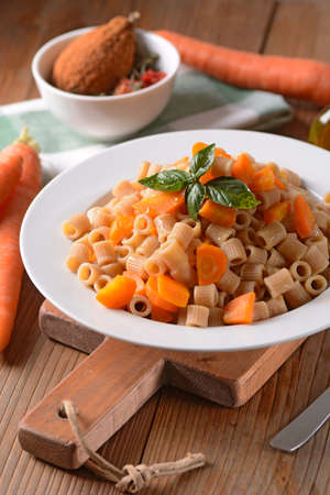 whole wheat pasta with carrots in the white plateの写真素材