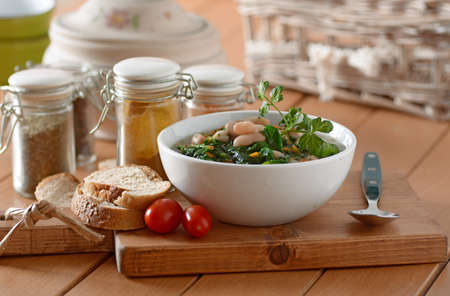 bean soup and spinach in white bowlの写真素材