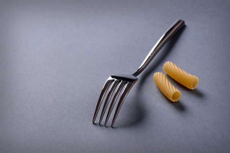 cutlery and Italian pasta on gray tableの写真素材