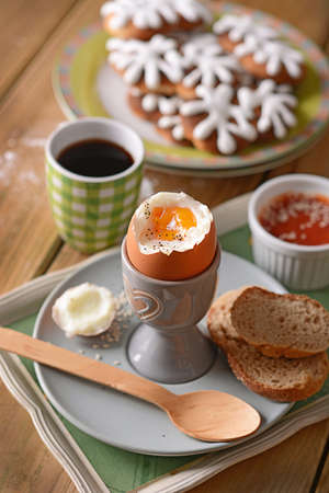 soft-boiled egg with slices of bread for breakfast on the wooden table