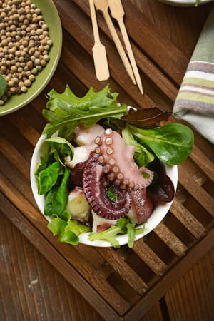 octopus salad with assorted vegetables in white bowl.の写真素材