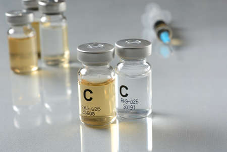 Vaccine in the vial with syringe near - closeup