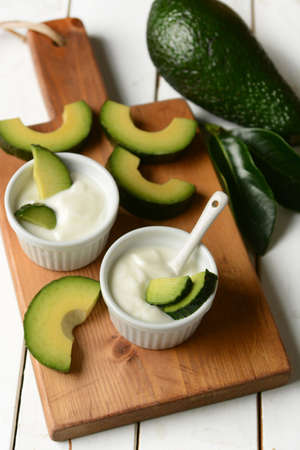 yogurt with avocado in bowl on wooden table - closeupの写真素材