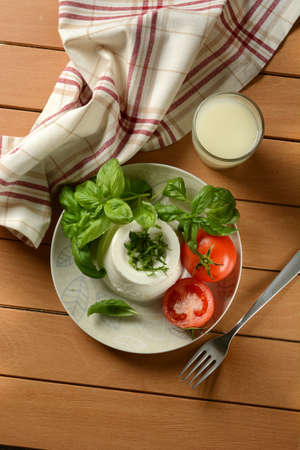 ricotta cheese with basil and tomatoes - traditional Italian dairy product - closeupの写真素材