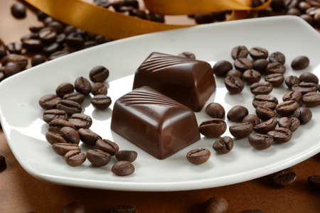 Coffee chocolates with coffee beans next to it - closeup