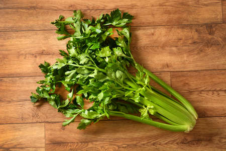 A bunch of celery on the wooden table - closeup