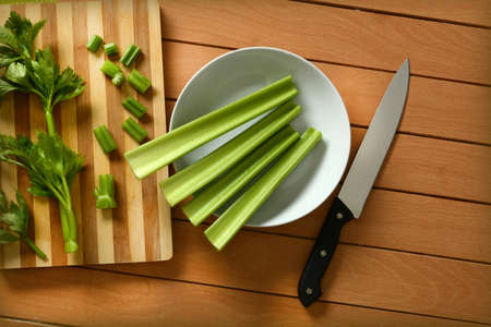 Celery cut with knife and chopping board - closeupの写真素材