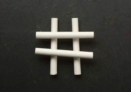 the hashtag symbol made with chalks - black background - closeupの写真素材