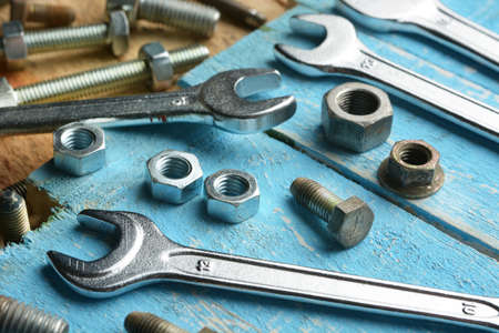 bolts and english wrenches on wooden table - closeup